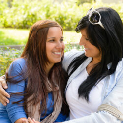 mother | Arizona Reproductive Medicine | Mother and daughter smiling at each other on park bench