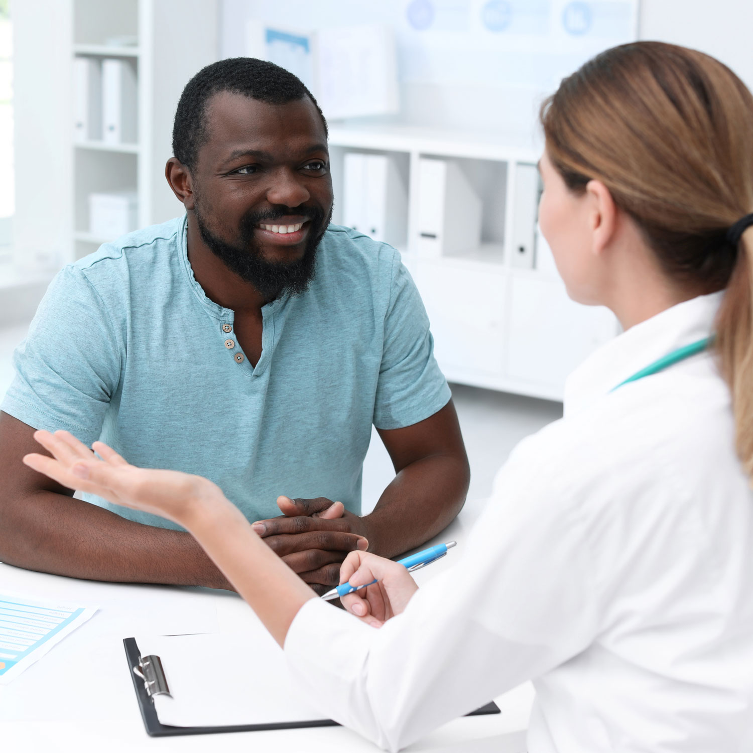 Man in blue shirt talking about treatments for male infertility with his doctor at ARMS | Arizona Reproductive Medicine Specialists