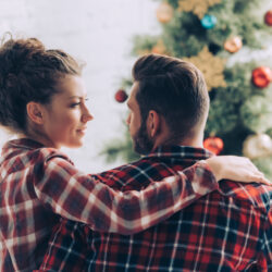 A couple celebrating around a Christmas tree | Arizona Reproductive Medicine Specialists | Phoenix