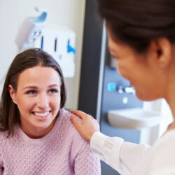 Nurse comforting a smiling patient | Arizona Reproductive Medicine Specialists | Phoenix